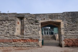 The modern college building just in sight through the arched doorway